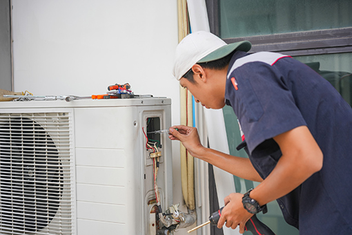 Employee of a Florida Company with Class B HVAC License Fixing an Air Conditioner