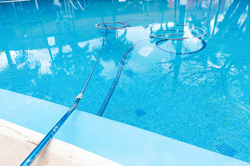 Swimming Pool in Florida Being Cleaned by Licensed Pool Service Contractor Using a Pool Vacuum
